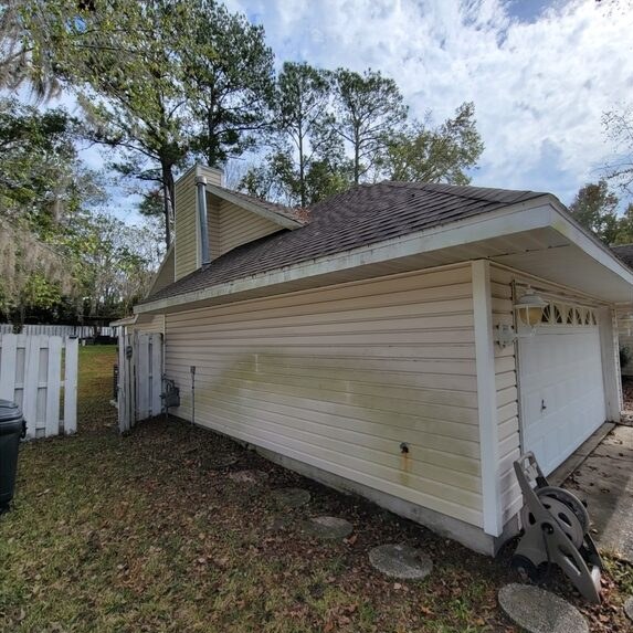 Vinyl siding with green and yellow buildup before house washing